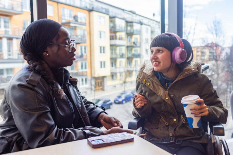 Two friends connect at a coffee shop.