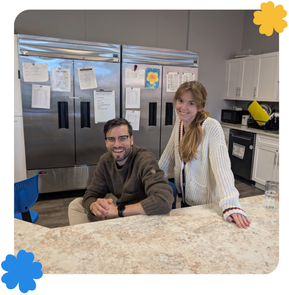 Two smiling VYES team members in a kitchen.