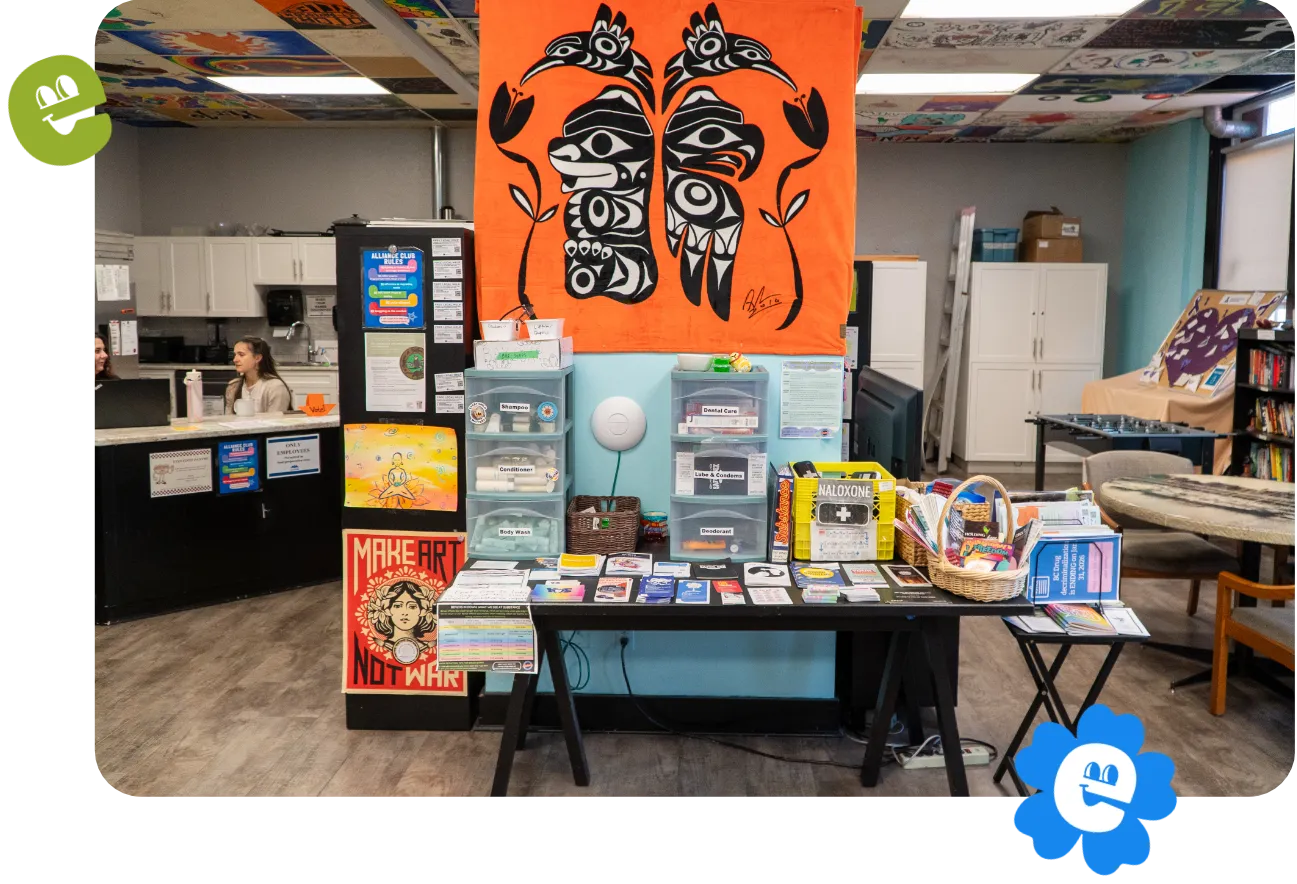 Alliance club welcome display with information pamphlets. A large First Nations artwork banner is displayed above.