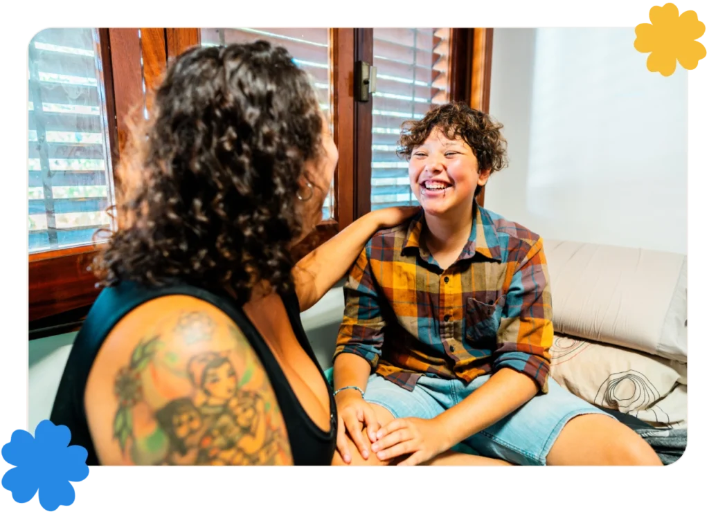A smiling young transgender man connects with a family member.